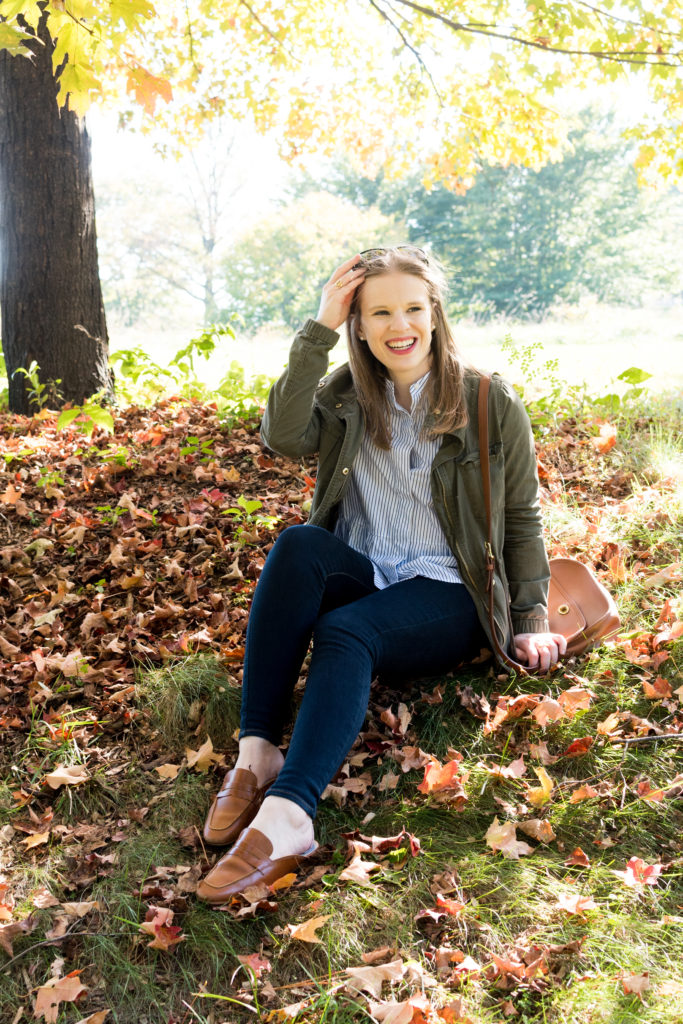 woman blogger wearing utility jacket outdoos in leaves