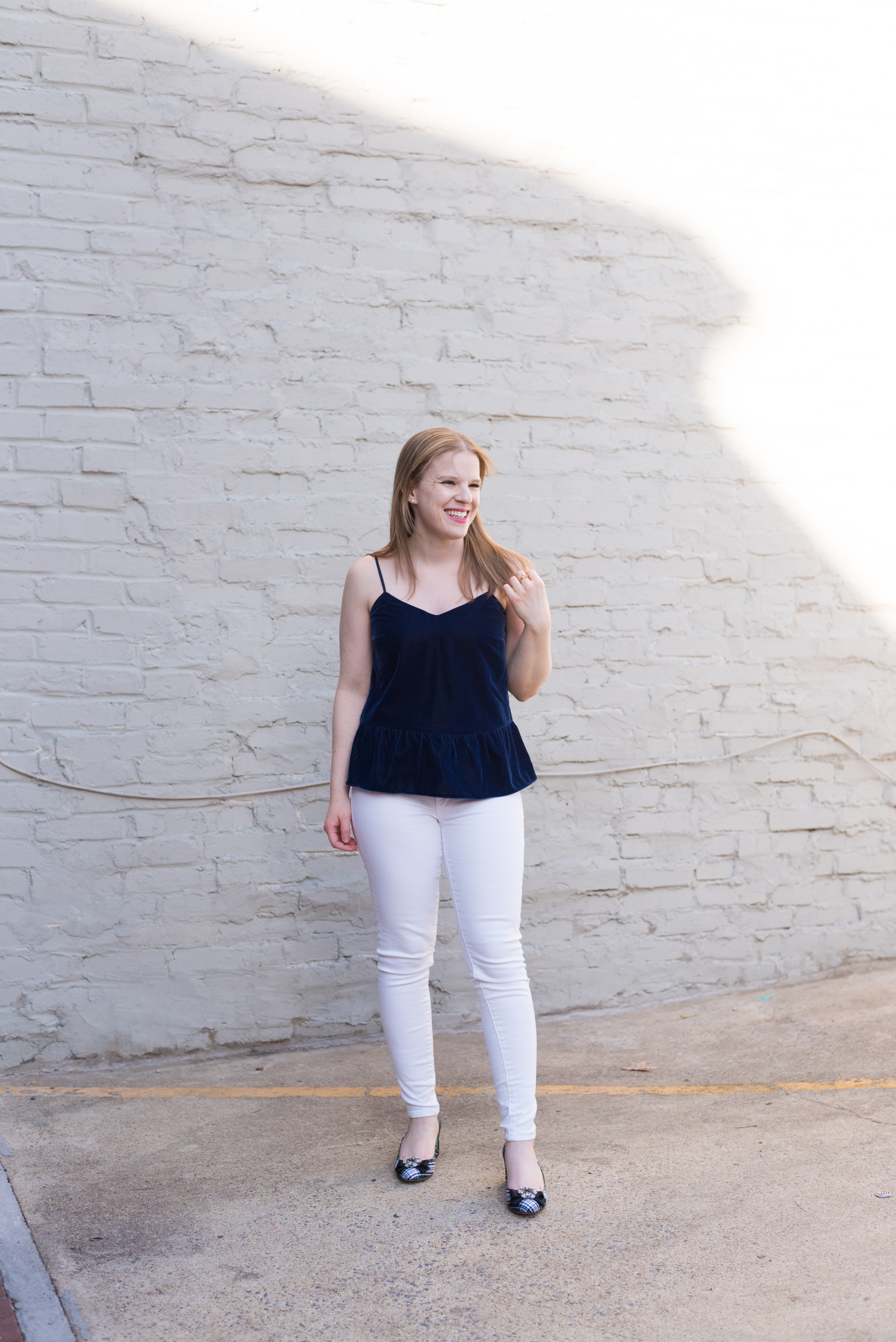 woman blogger wearing velvet peplum tank and white skinny jeans
