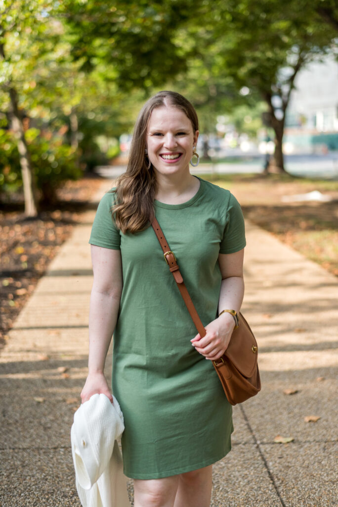 woman blogger wearing green dress carrying cardigan