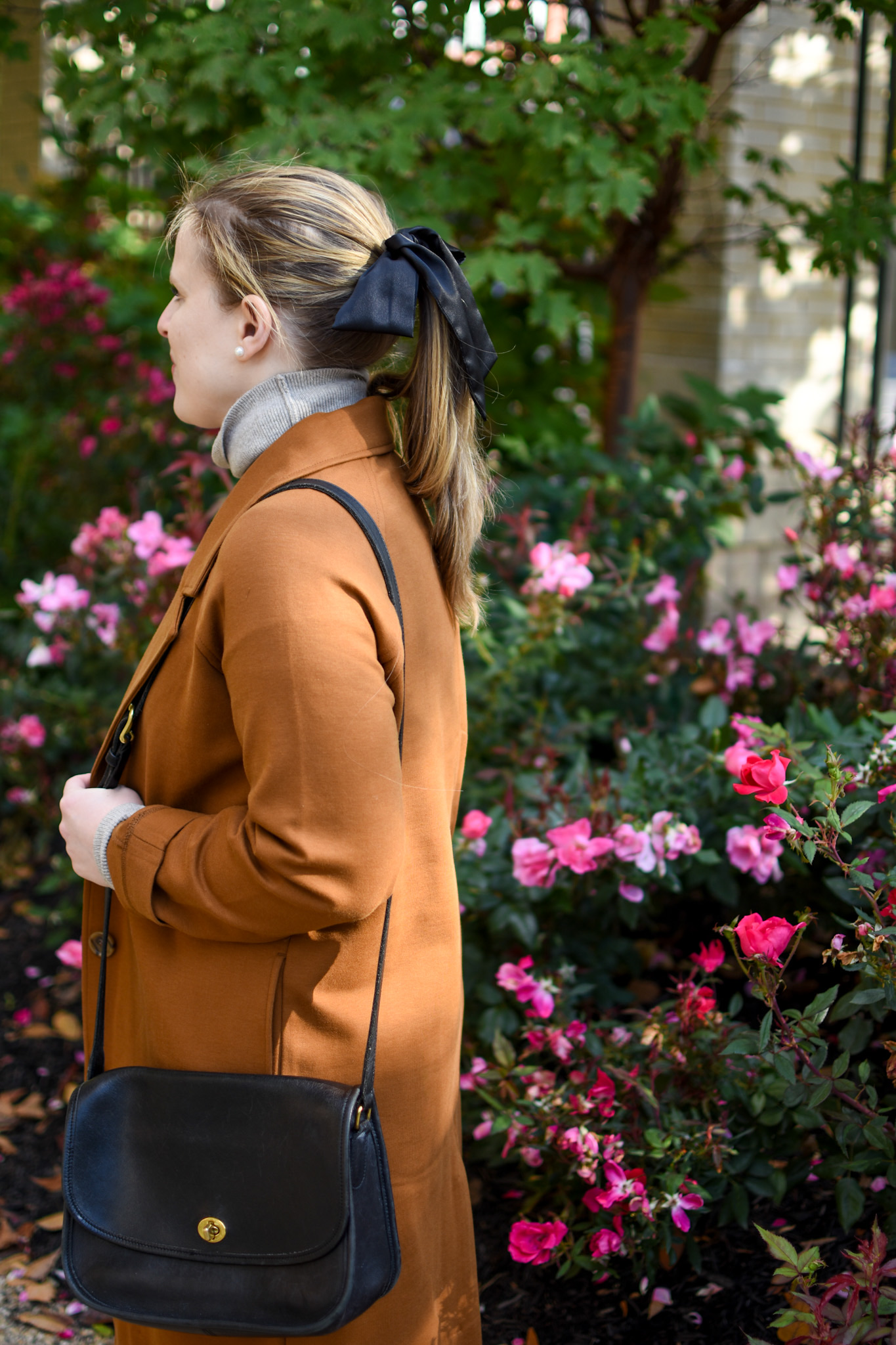woman blogger wearing Everlane trench coat and carrying Coach Classic City Bag