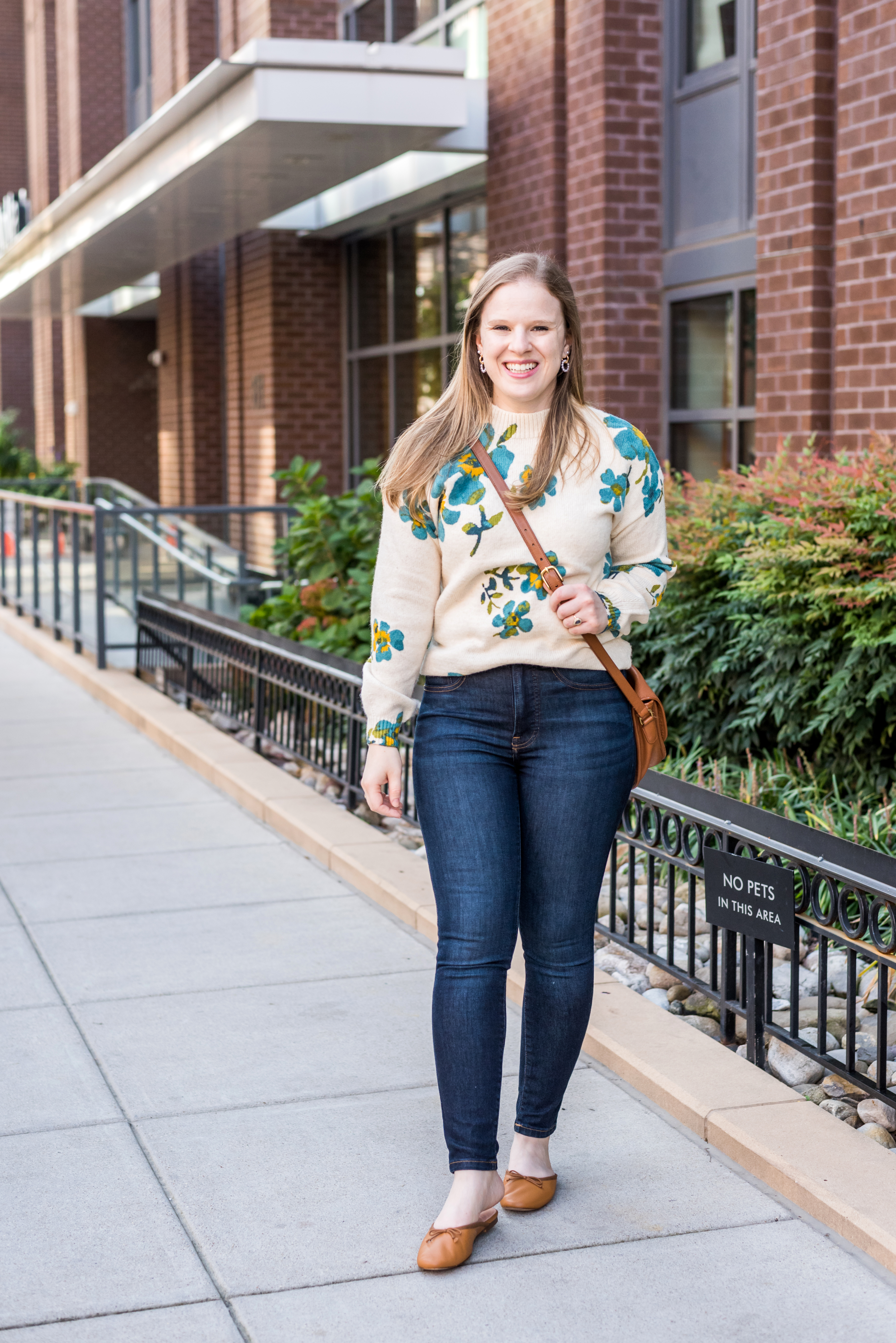 woman wearing loft floral sweater, jeans, and mules 