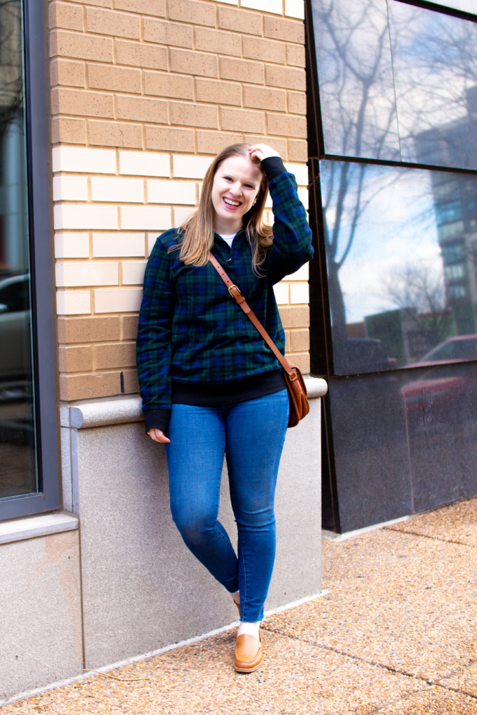 woman blogger leaning on brick wall wearing Ralph Lauren pullover and Everlane denim