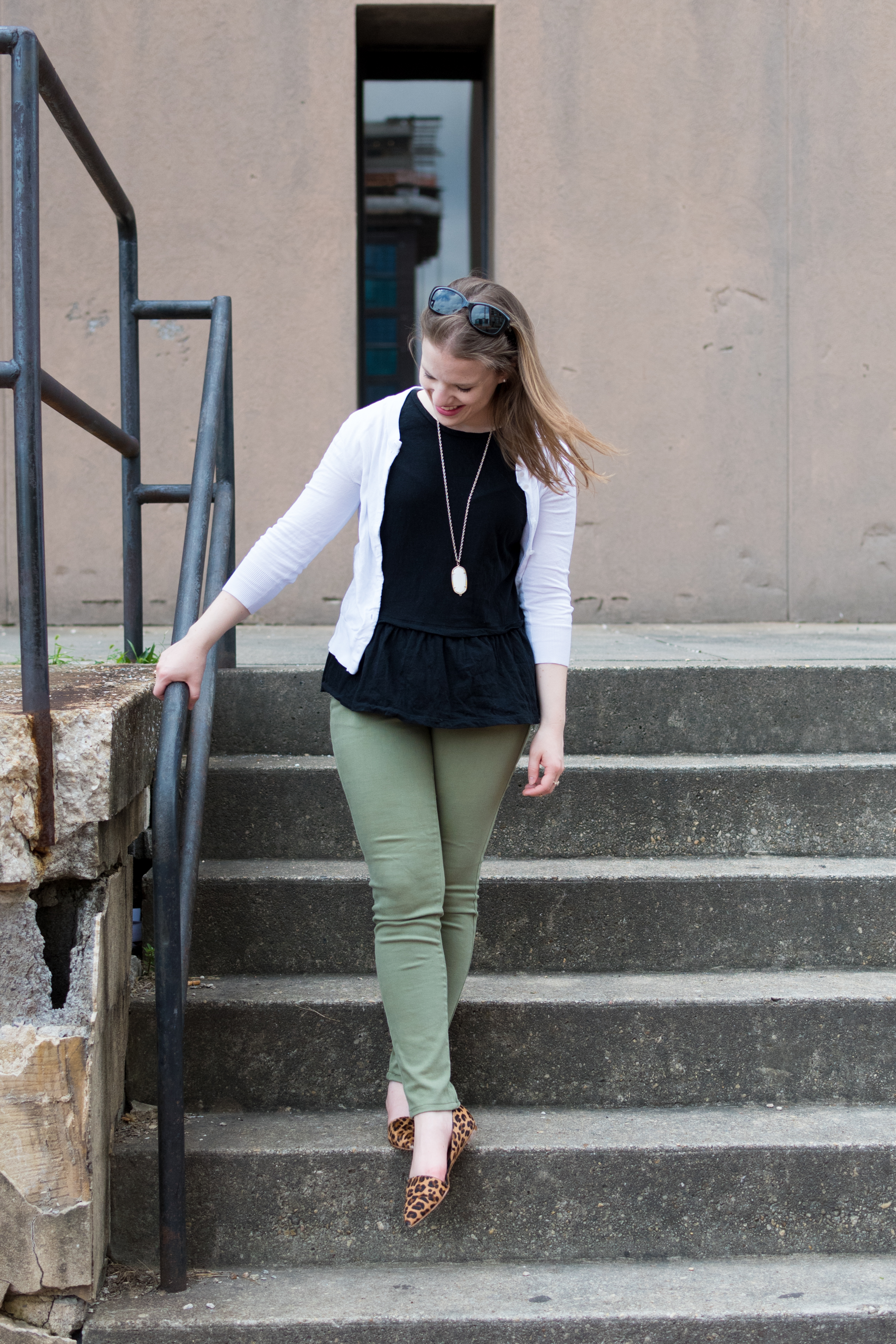 woman blogger wearing green skinny jeans and leopard print mules