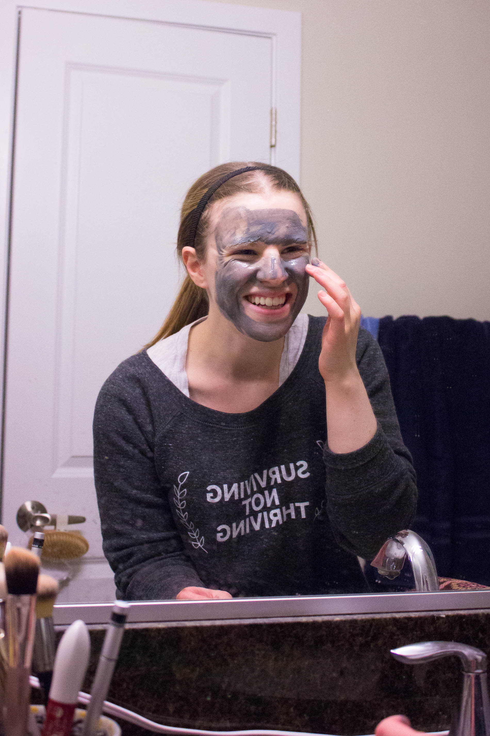 woman using beauty face mask, woman trying on Bioré One Minute Mask in mirror