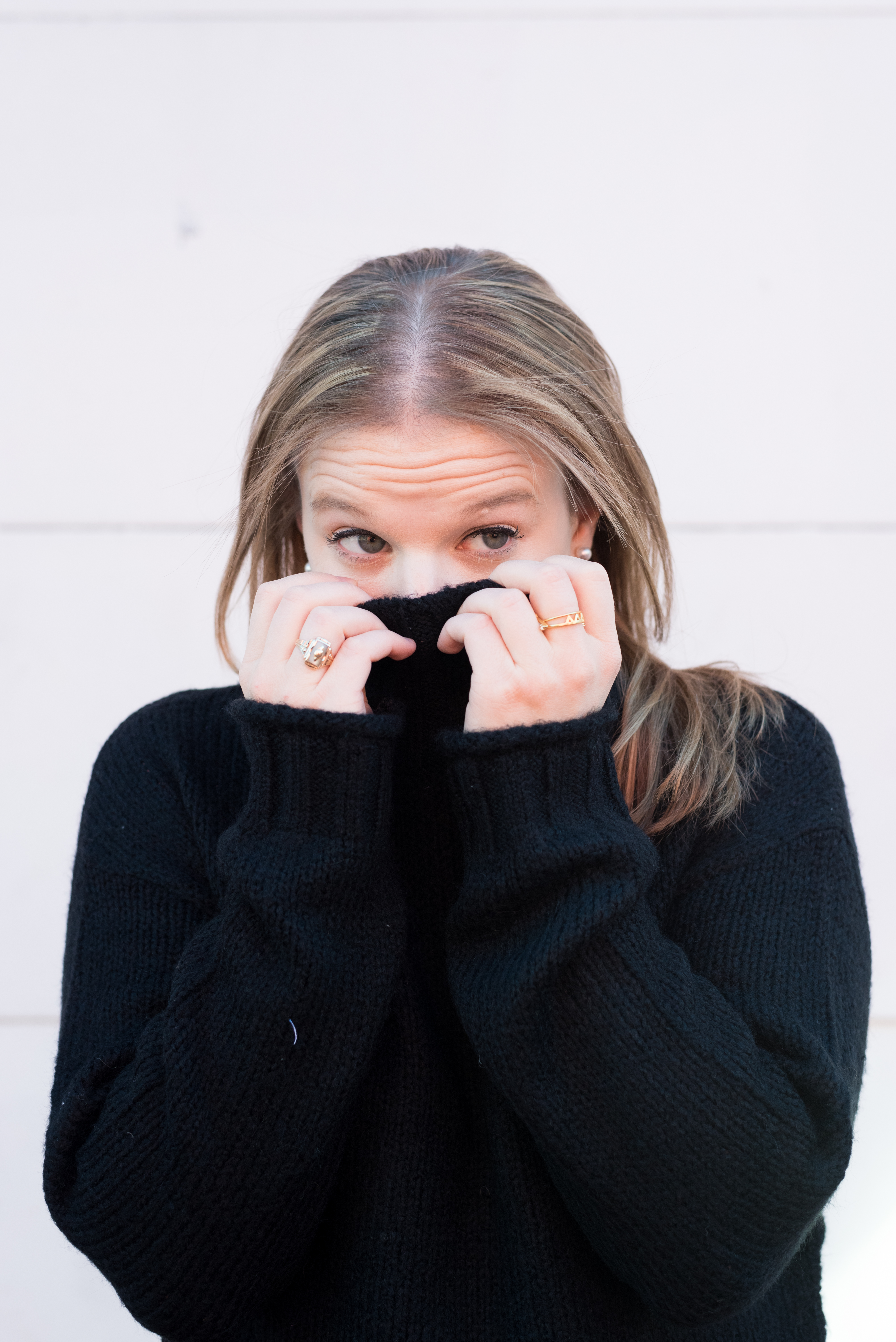 woman hiding, woman in black sweater