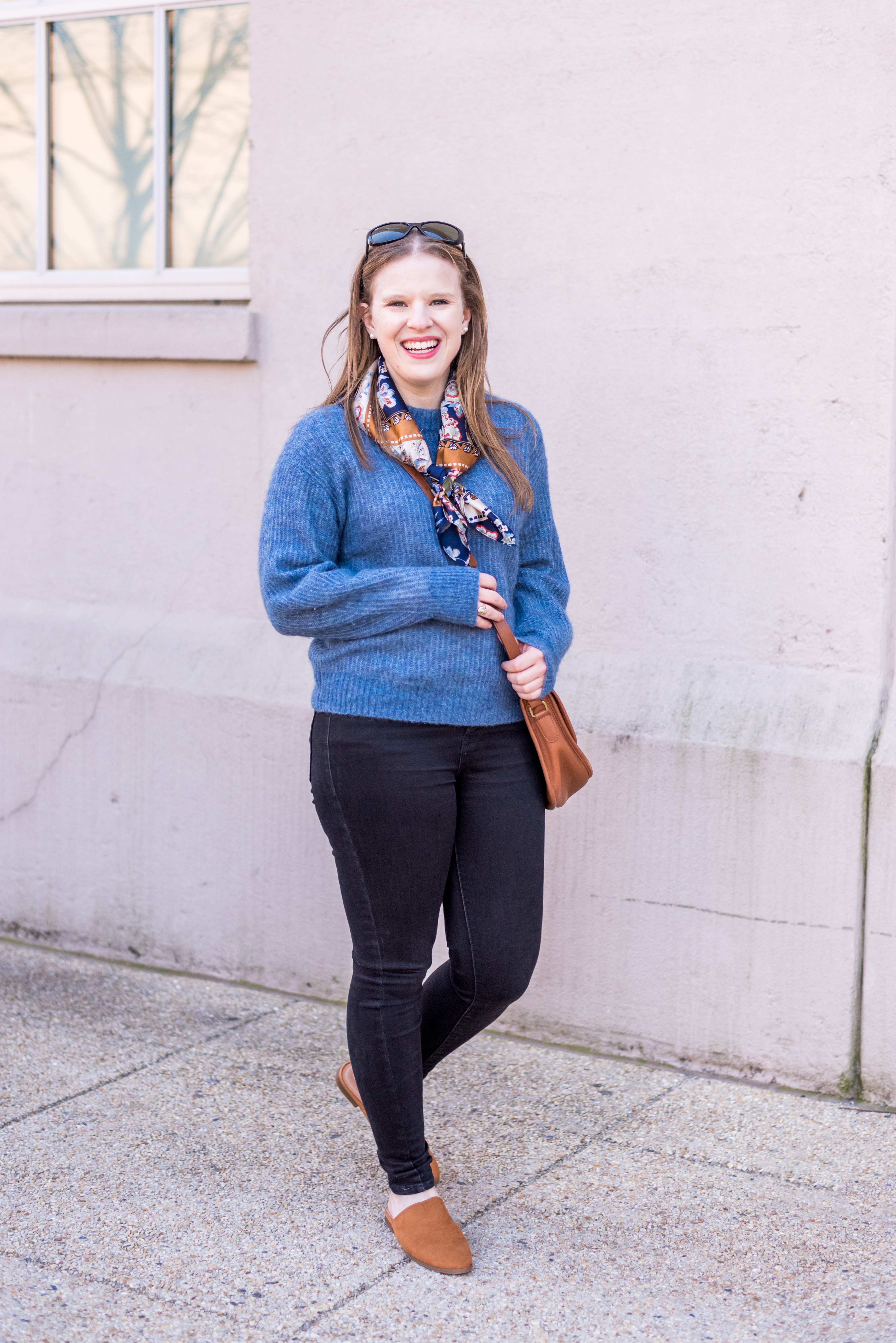 women wearing cognac mules, blue sweater, and jeans 