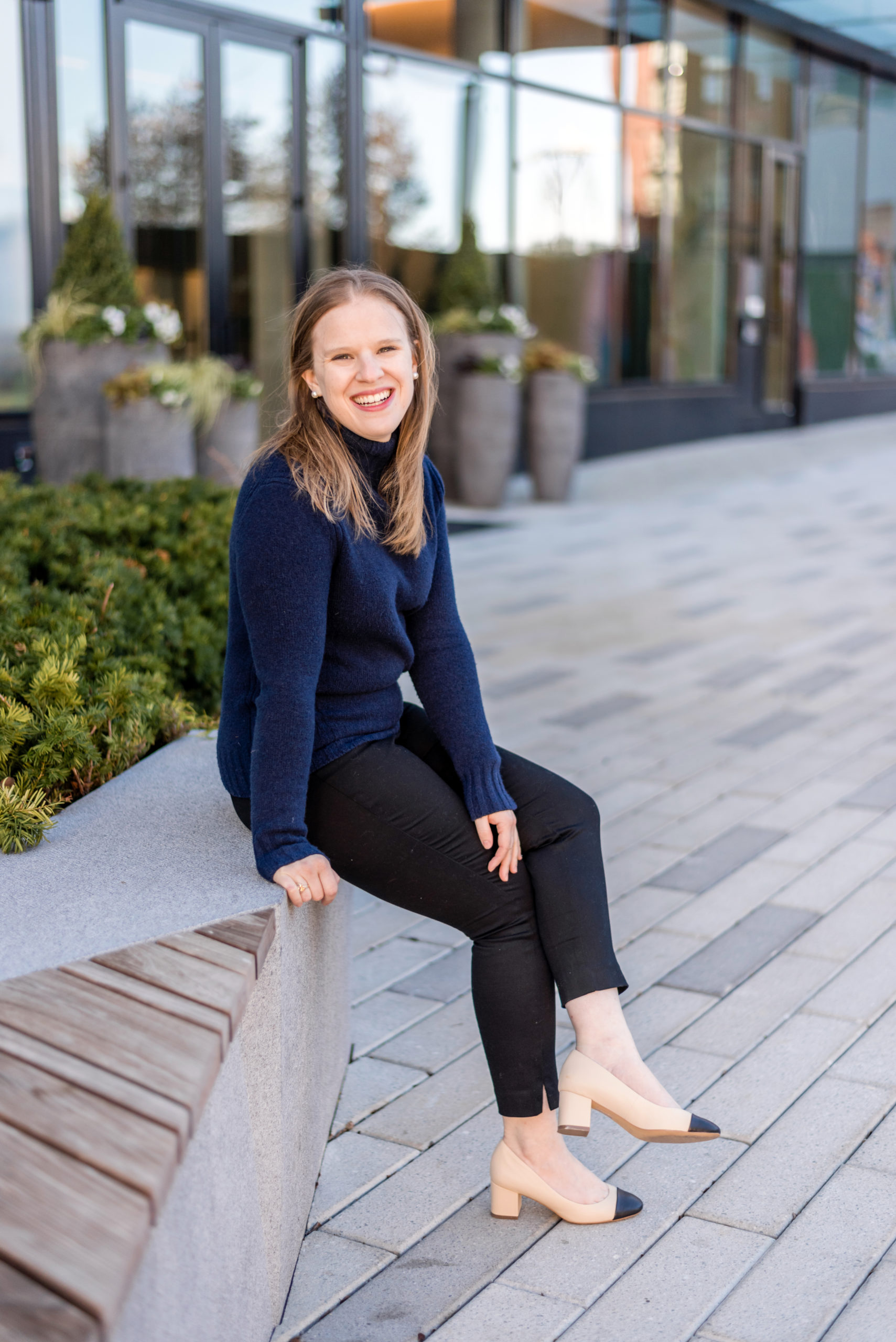 woman blogger wearing navy turtleneck sweater and heels