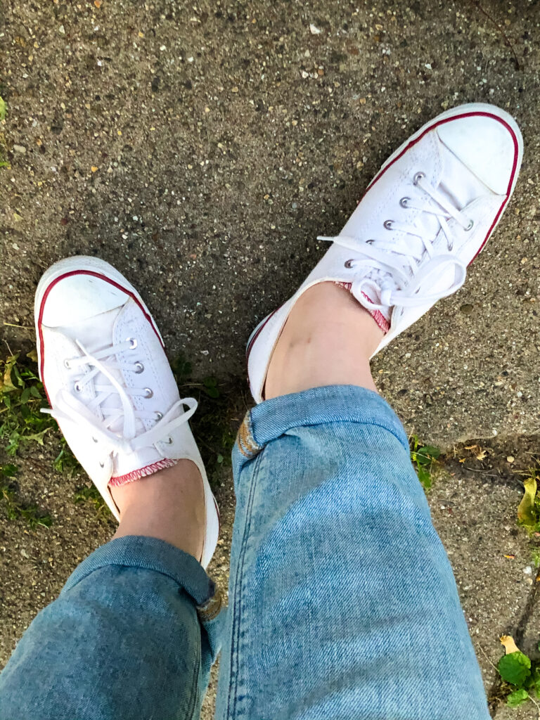 bird's eye view of low-top converse and jeans