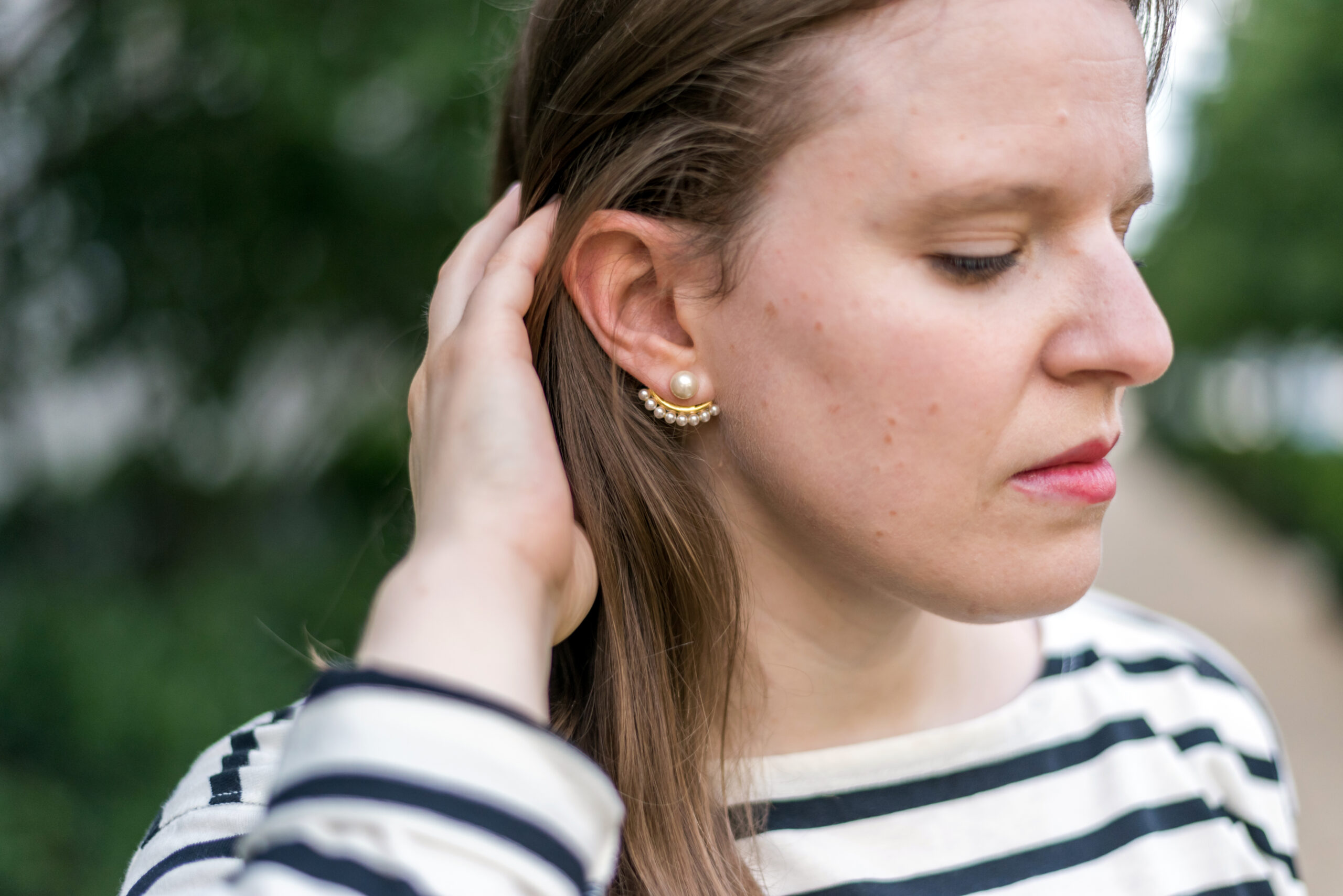 woman blogger wearing pearl earring and striped top