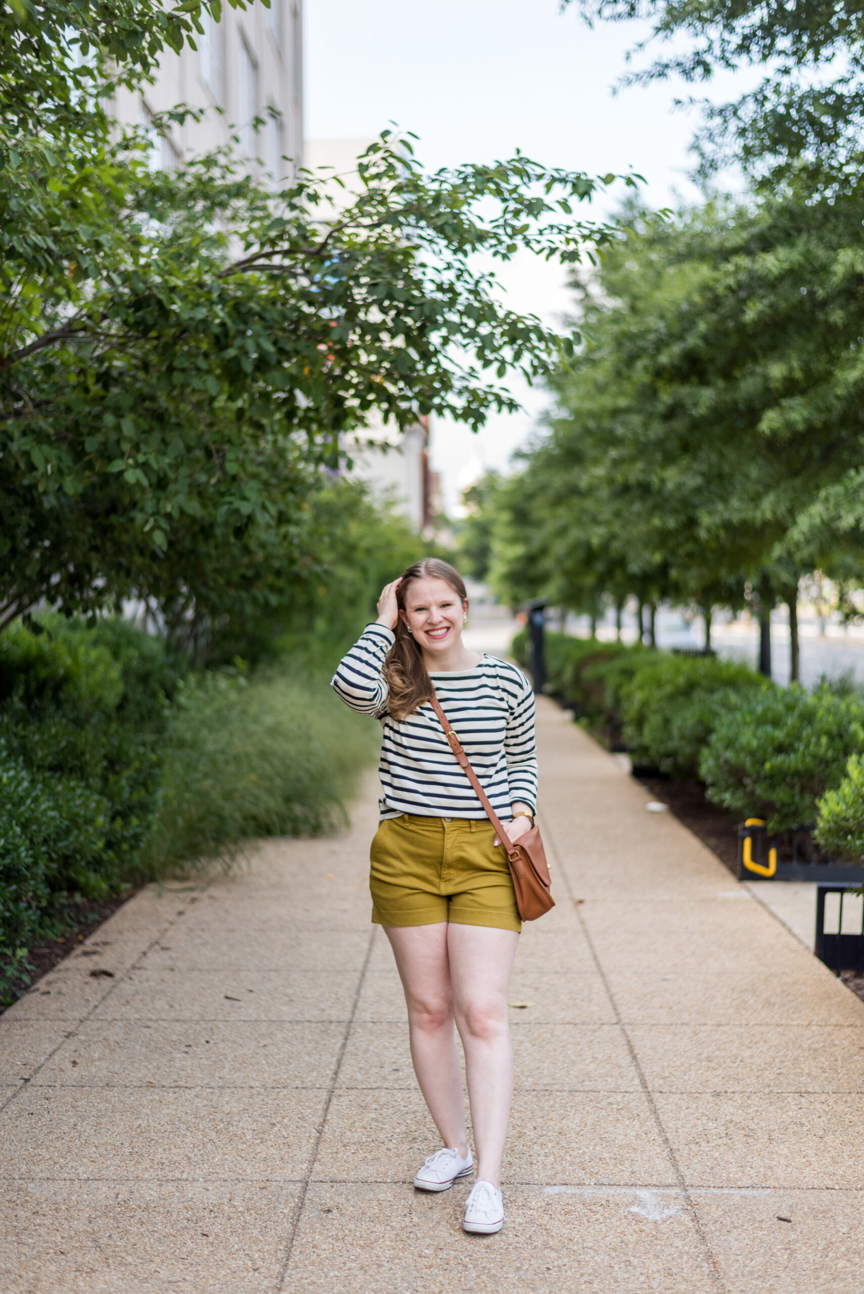 woman blogger wearing summer outfit with white Converse