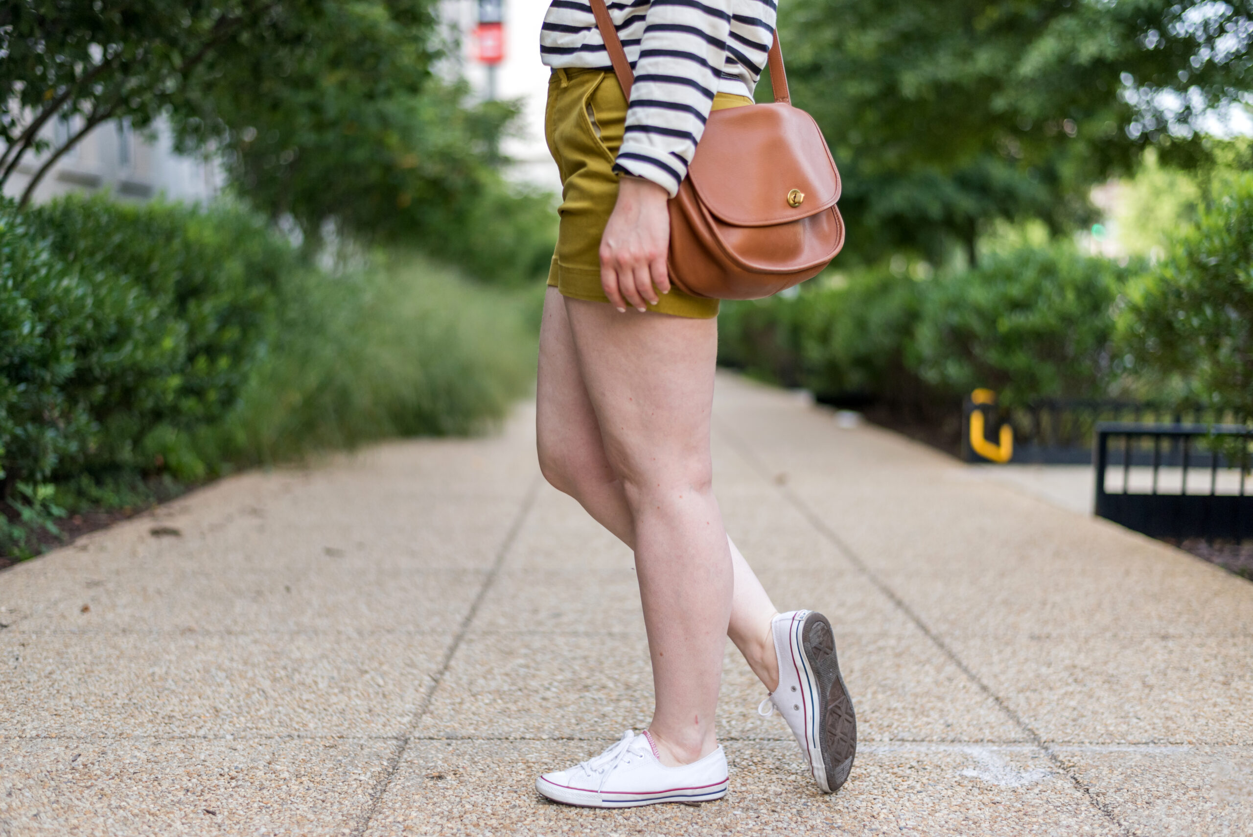 woman blogger wearing Converse Chuck Taylor Dainty Sneakers and mustard shorts