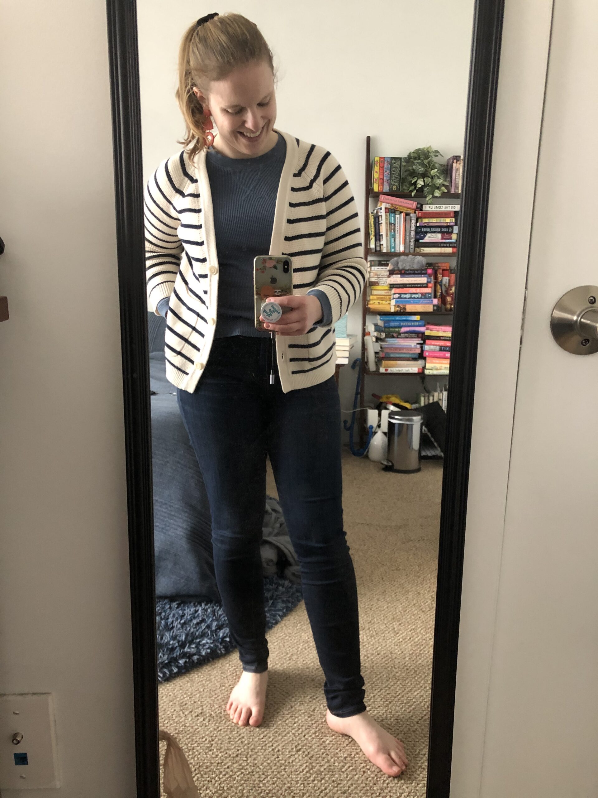 woman blogger taking mirror selfie and wearing striped cardigan