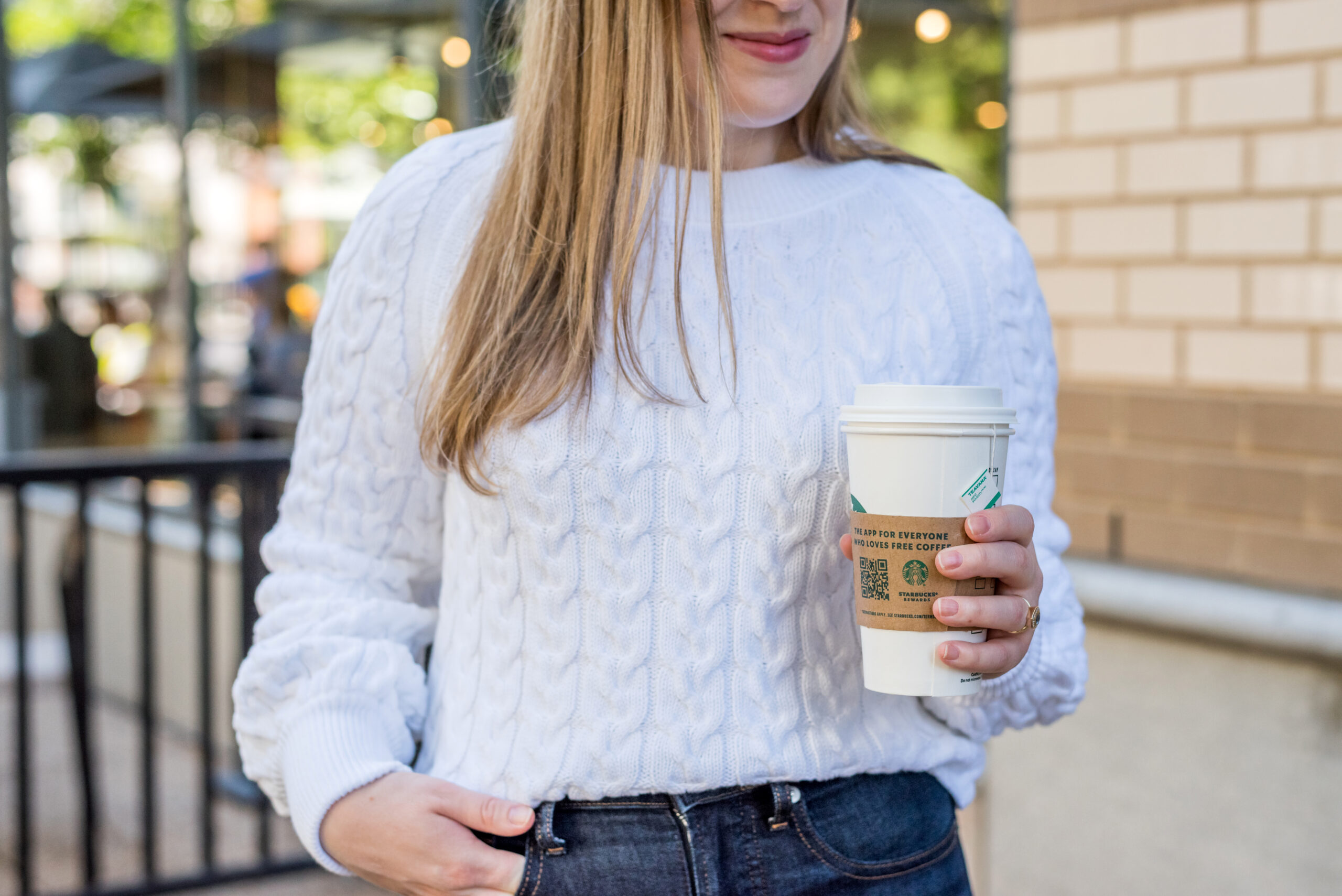 Woman wearing j.crew white cable knit sweater